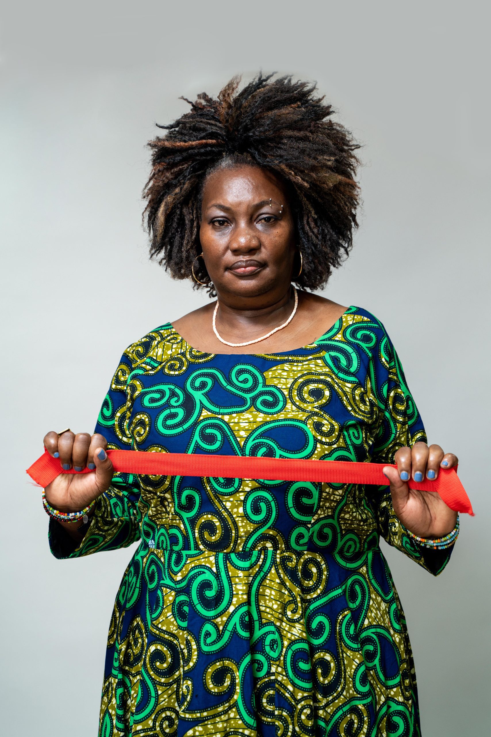 Woman holding a red rope to symbolise drawing a red line against conflict-related sexual violence