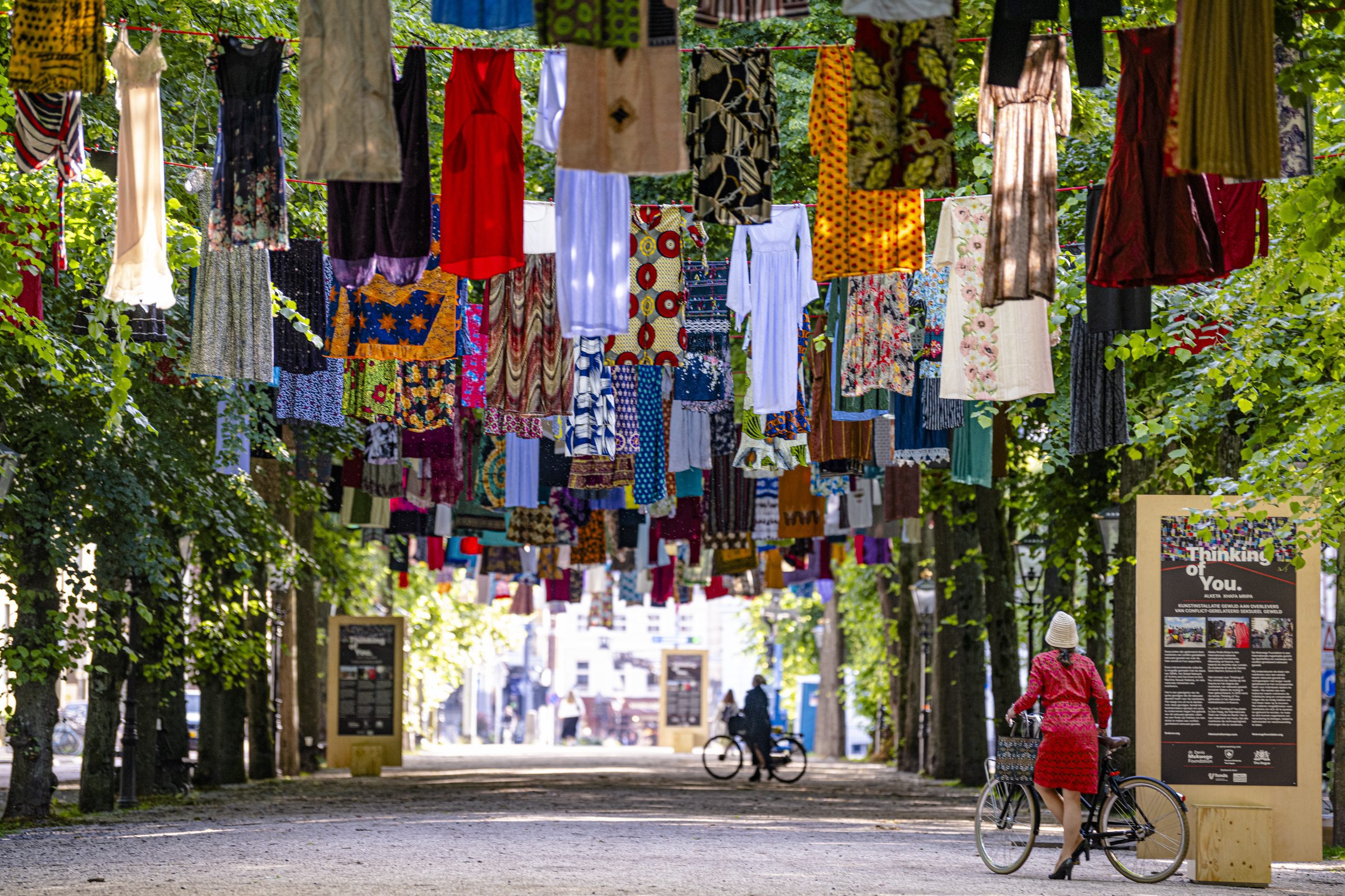 Hundreds of dresses donated by survivors hanging on the trees of the Lange Voorhout.