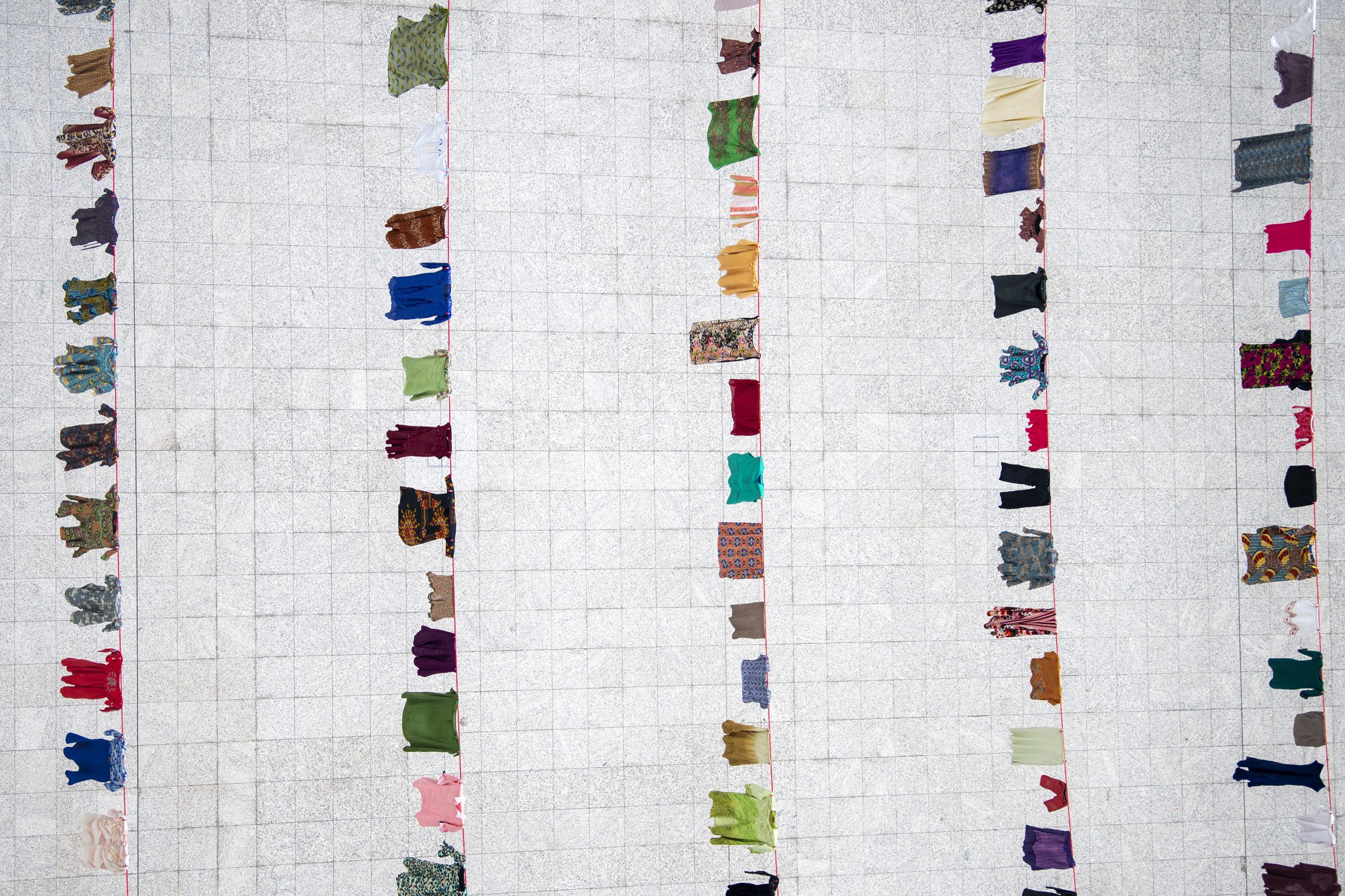 Washing lines filled with dresses donated by survivors in the Atrium City Hall of The Hague.